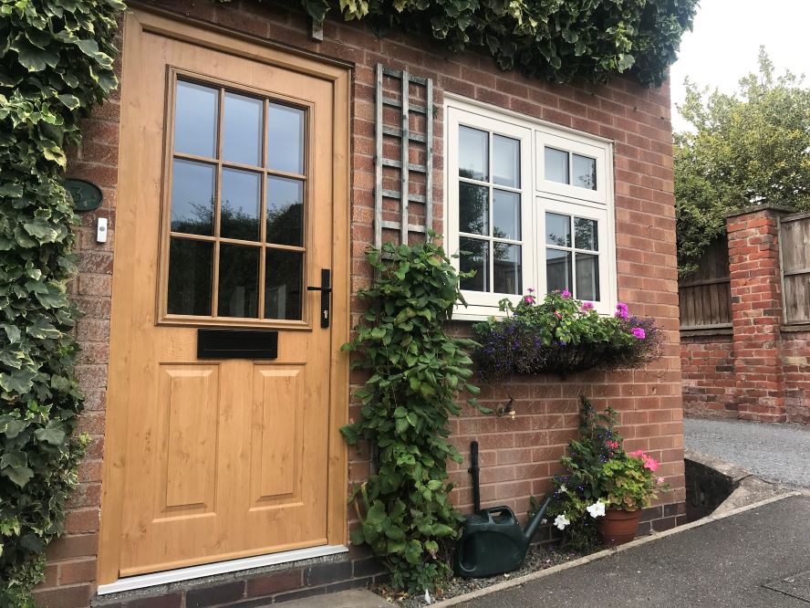 Clotted cream Residence 7 windows with astragal cottage style bars, surrounded by greenery and oak effect front door